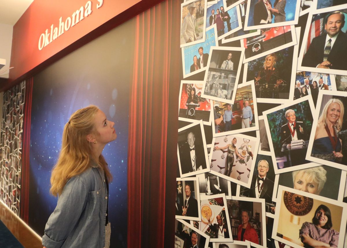 A female Museum guest looks at the picture collage of Inductees.