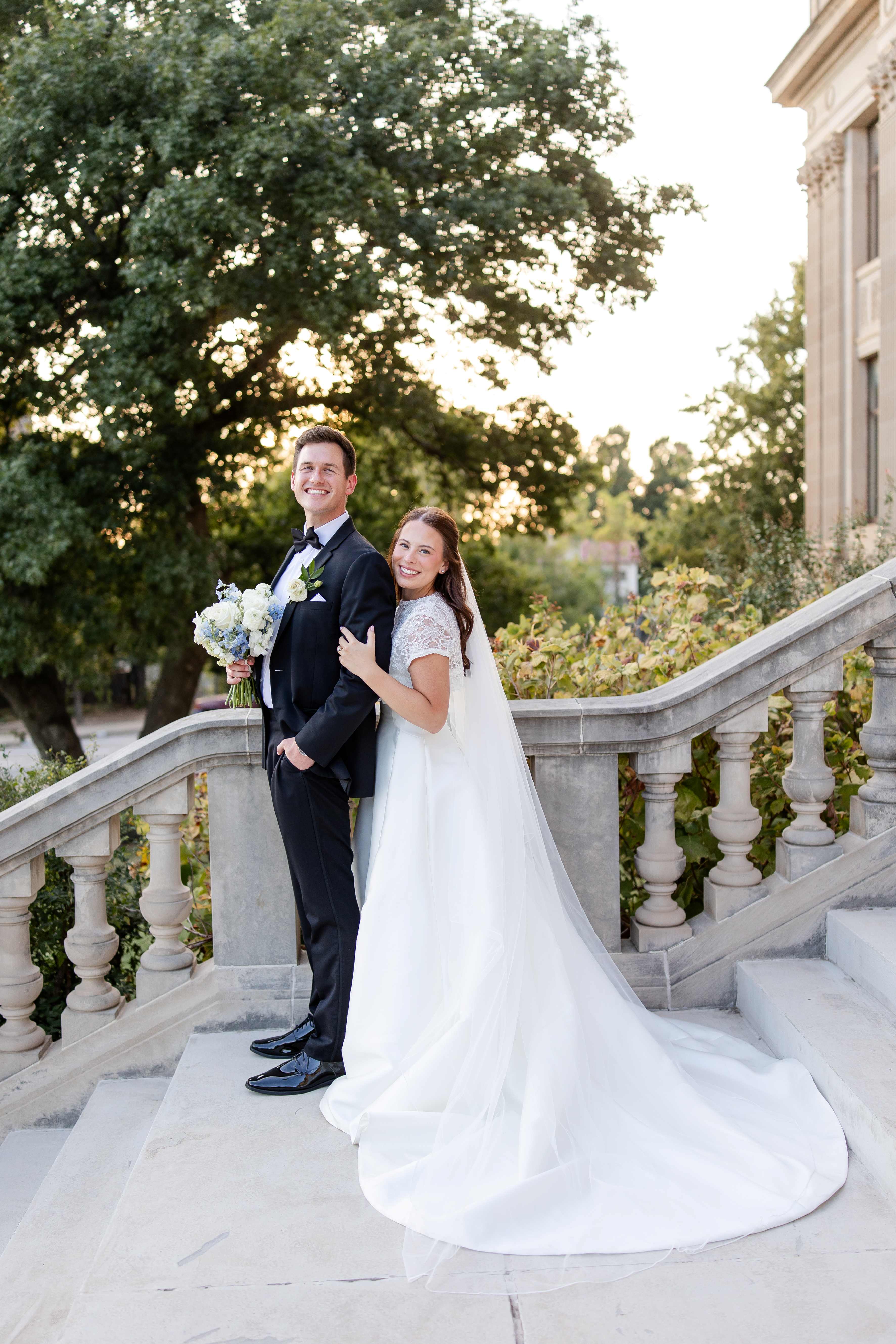 A bride and groom pose on the front steps of the Oklahoma Hall of Fame