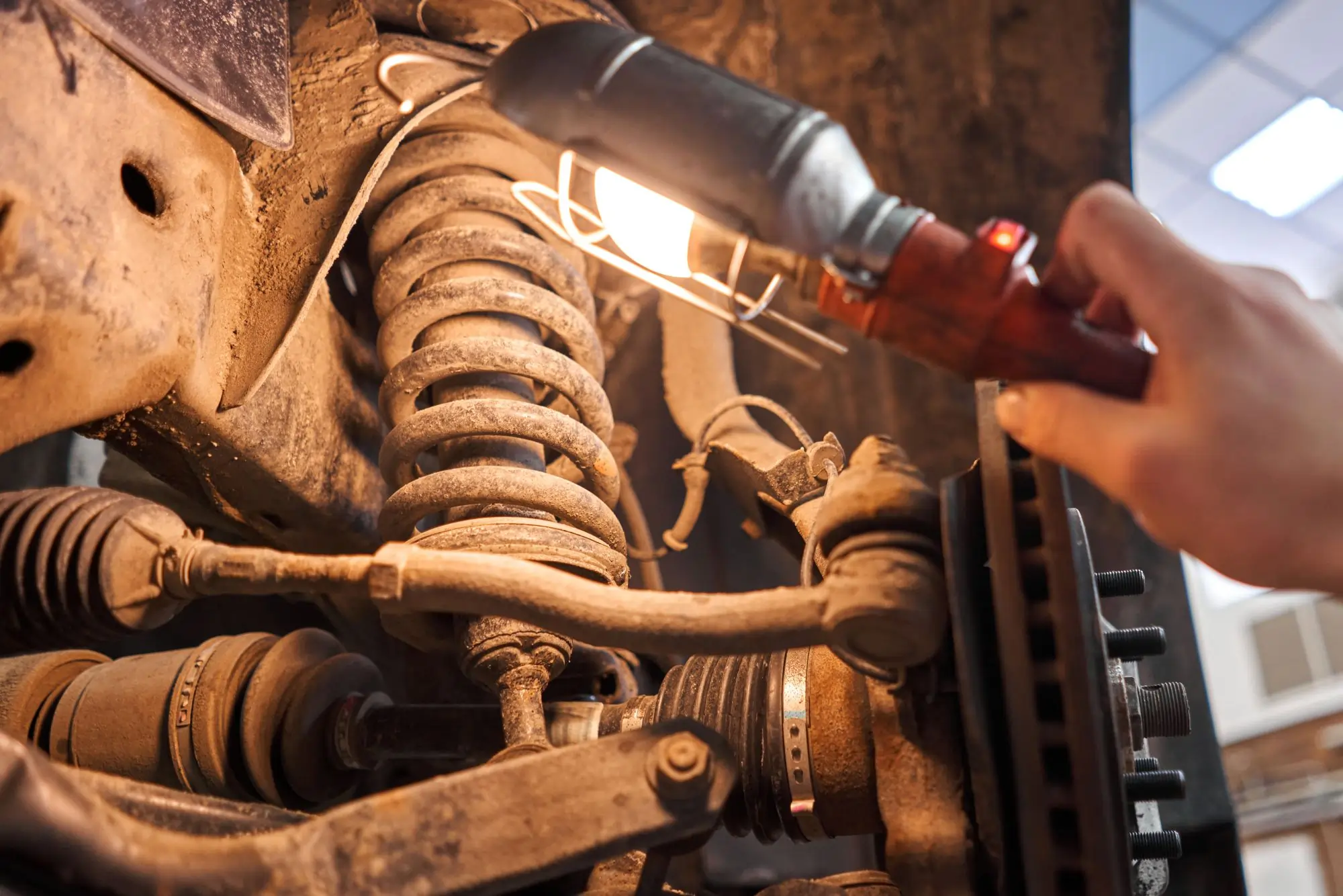 technician inspecting truck suspension for wear at FleetGo shop in Alberta