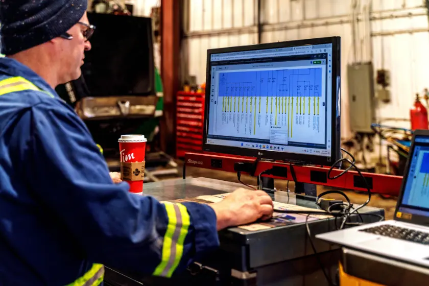 Fleetgo technician reviewing a truck wiring diagram on a diagnostic workstation in the Edmonton shop
