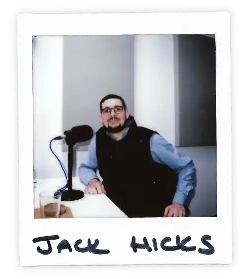 Polaroid of Jack Hicks in the Oxford Podcast Studio sat at the table with a microphone.