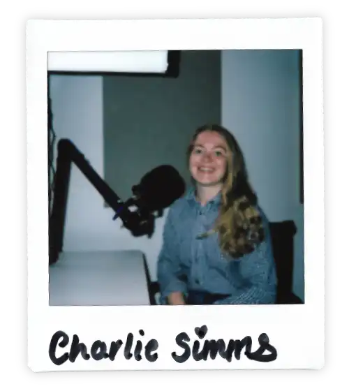 Polaroid of Charlie Simms in the Oxford Podcast Studio sat at the table with a microphone.