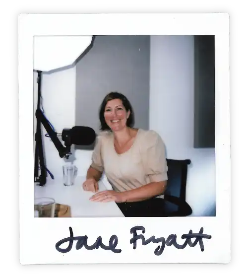 Polaroid of Jane Fryatt in the Oxford Podcast Studio sat at the table with a microphone.