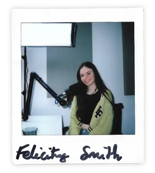 Polaroid of Felicity Smith in the Oxford Podcast Studio sat at the table with a microphone.