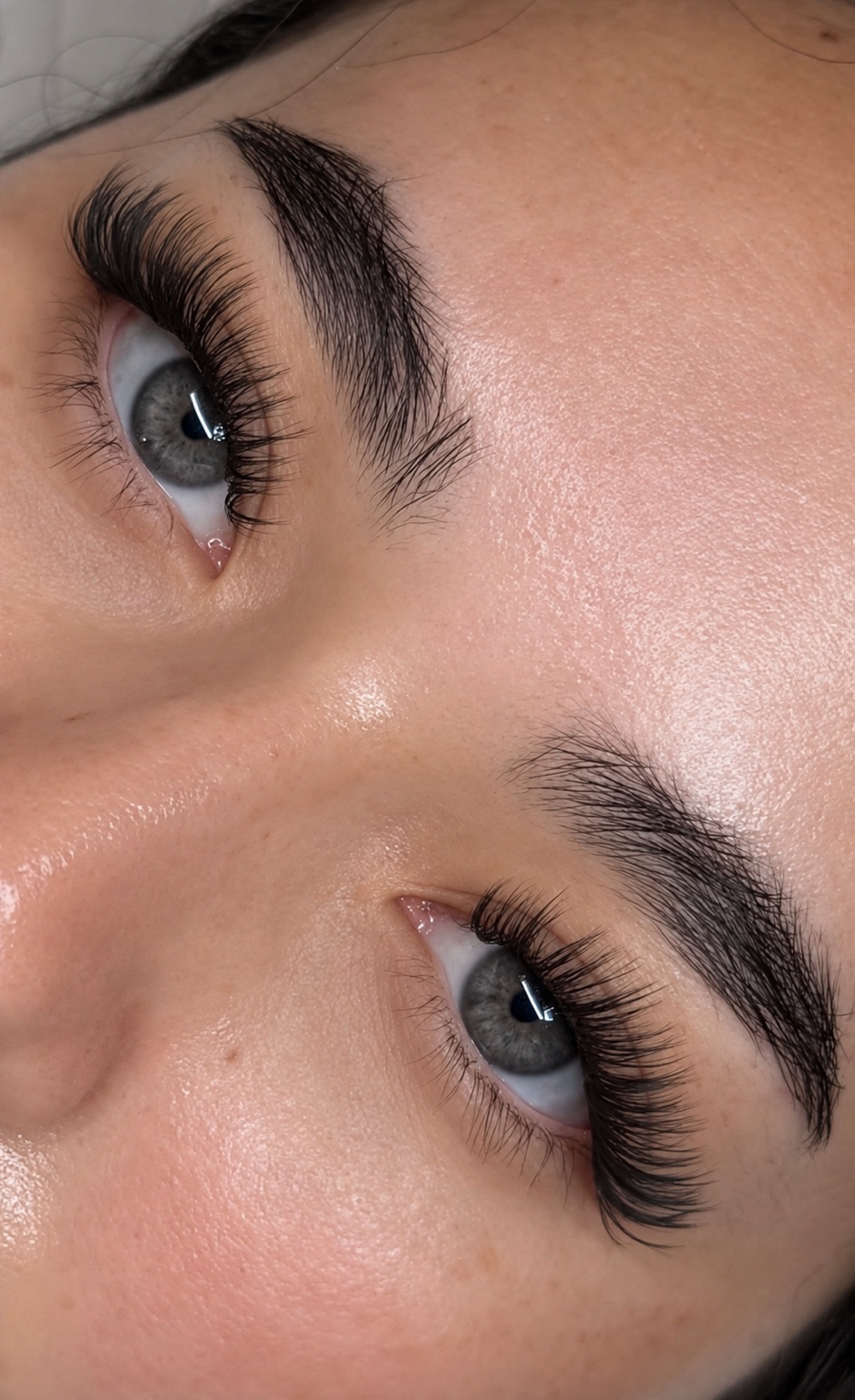 Lash extensions and defined brows with natural skin texture