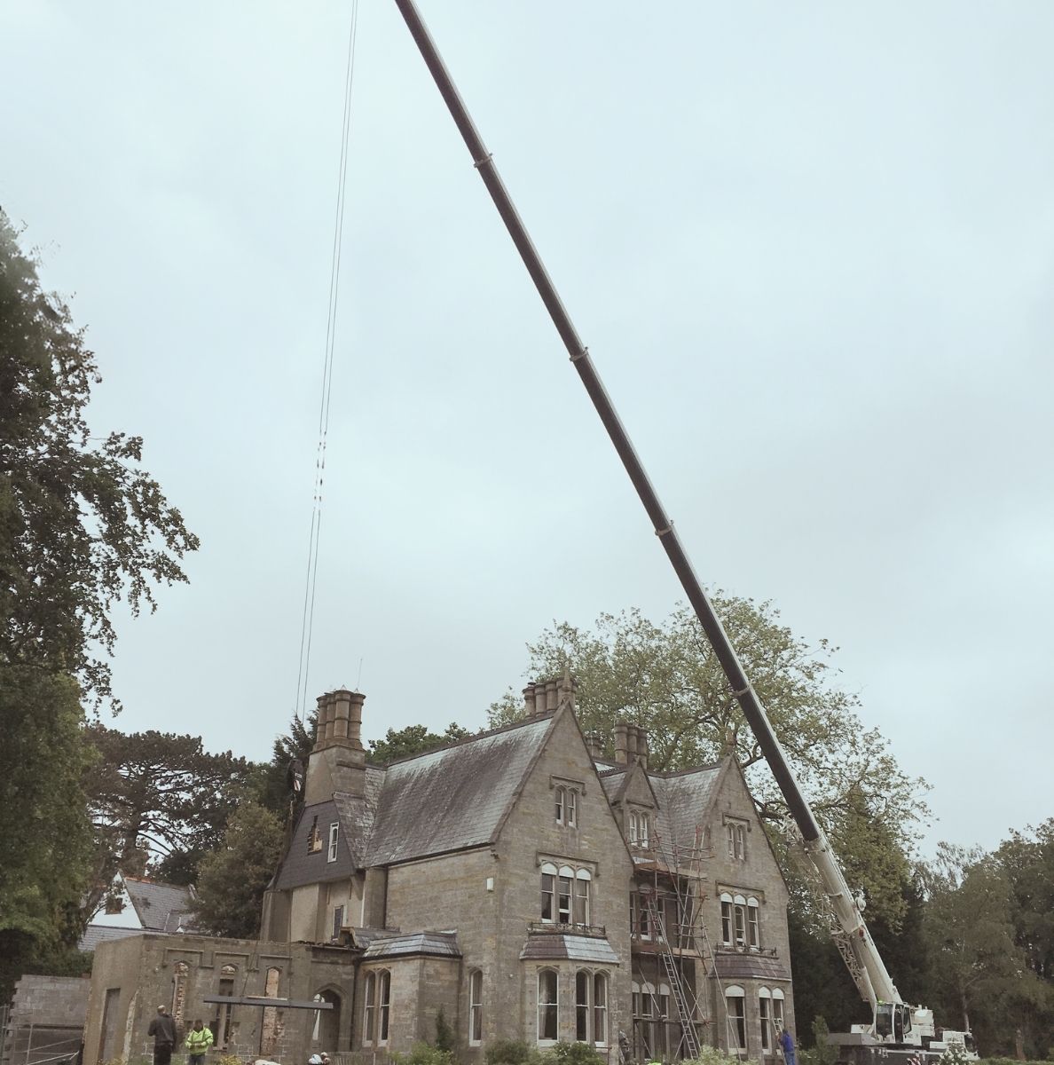 Crane transporting steel frame above a listed Victorian home.