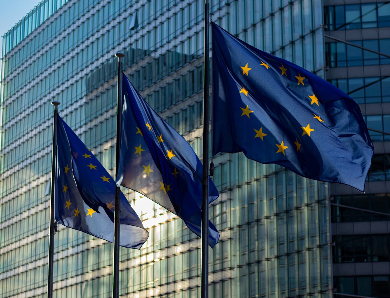 Drapeaux européens flottant devant un bâtiment vitré