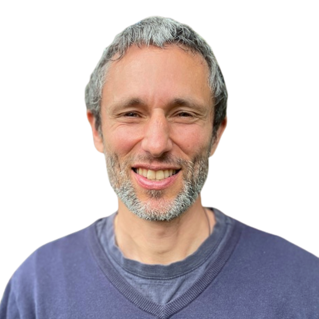 Headshot of Charles Eisenstein smiling and wearing a blue sweater.