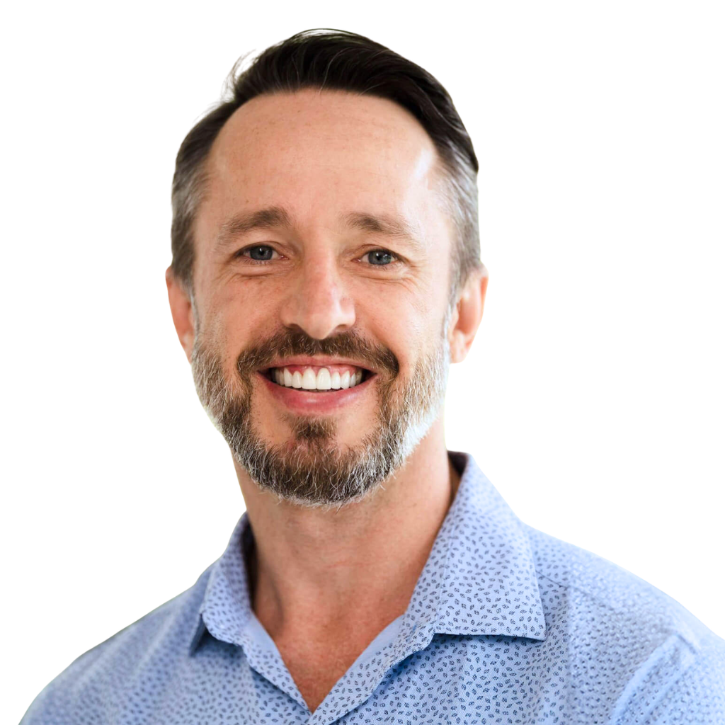 Headshot of Zach Geist, CEO of Holistic Finance, smiling and wearing a light blue collared shirt.