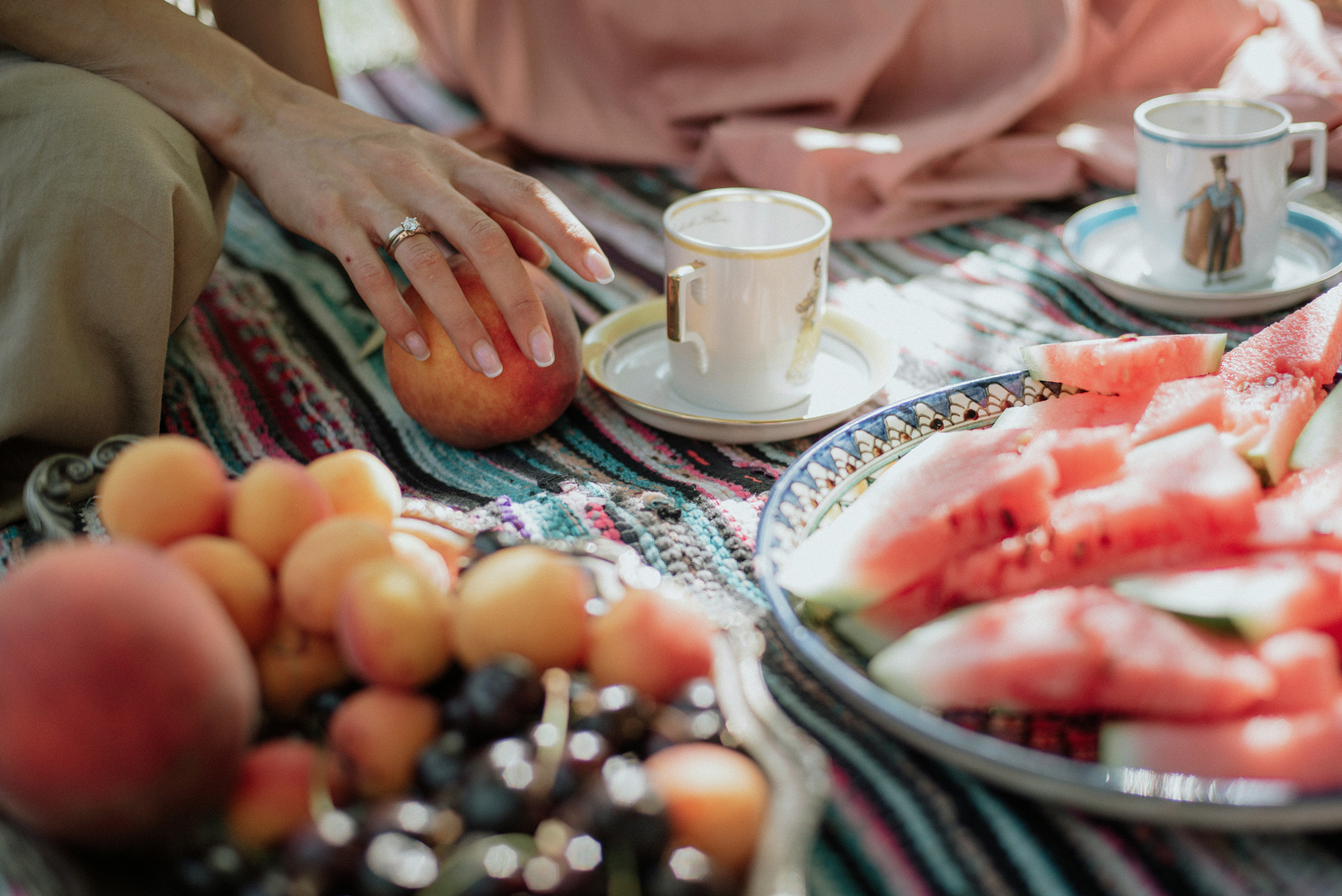 Close-up of fruit, watermelon, and coffee cups on a picnic blanket, representing lifestyle and financial planning.