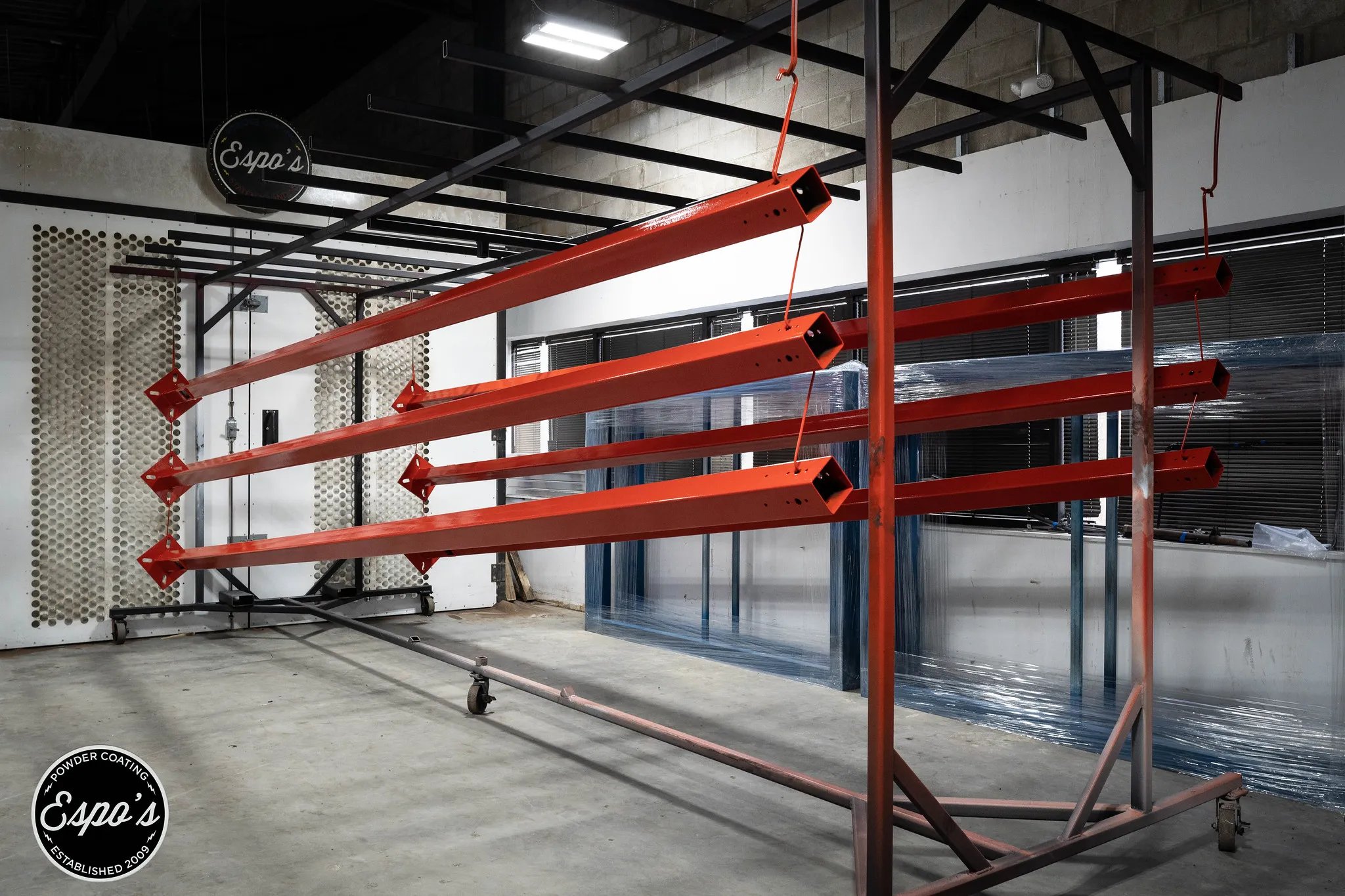 Red powder coated metal rack in the Espo's Powder Coating shop in Eatontown, NJ