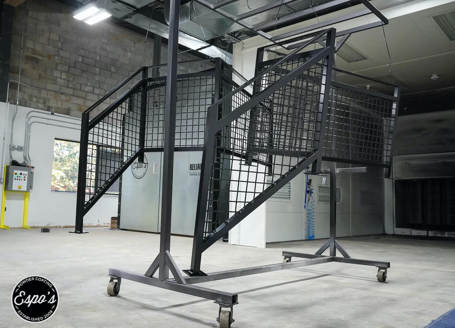Black powder coated stair railing on a cart at Espo's, residential powder coating in NJ