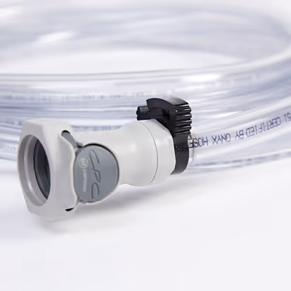 Close-up of a coiled transparent plastic tube with a white and gray valve and black clamp.