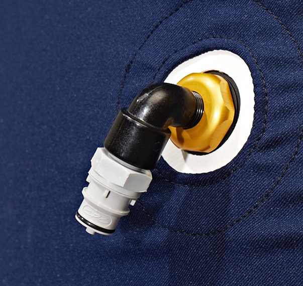 Close-up of a black elbow pipe connector attached to a gold-colored valve on a dark blue fabric surface.