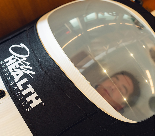 Man laying down inside an OxyHealth Hyperbarics chamber 