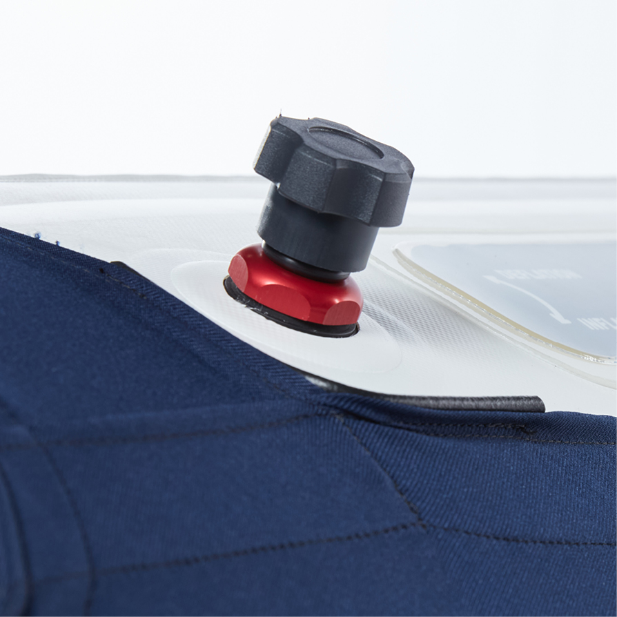Close-up of a black knob on a red base attached to a translucent surface with blue fabric adjacent.
