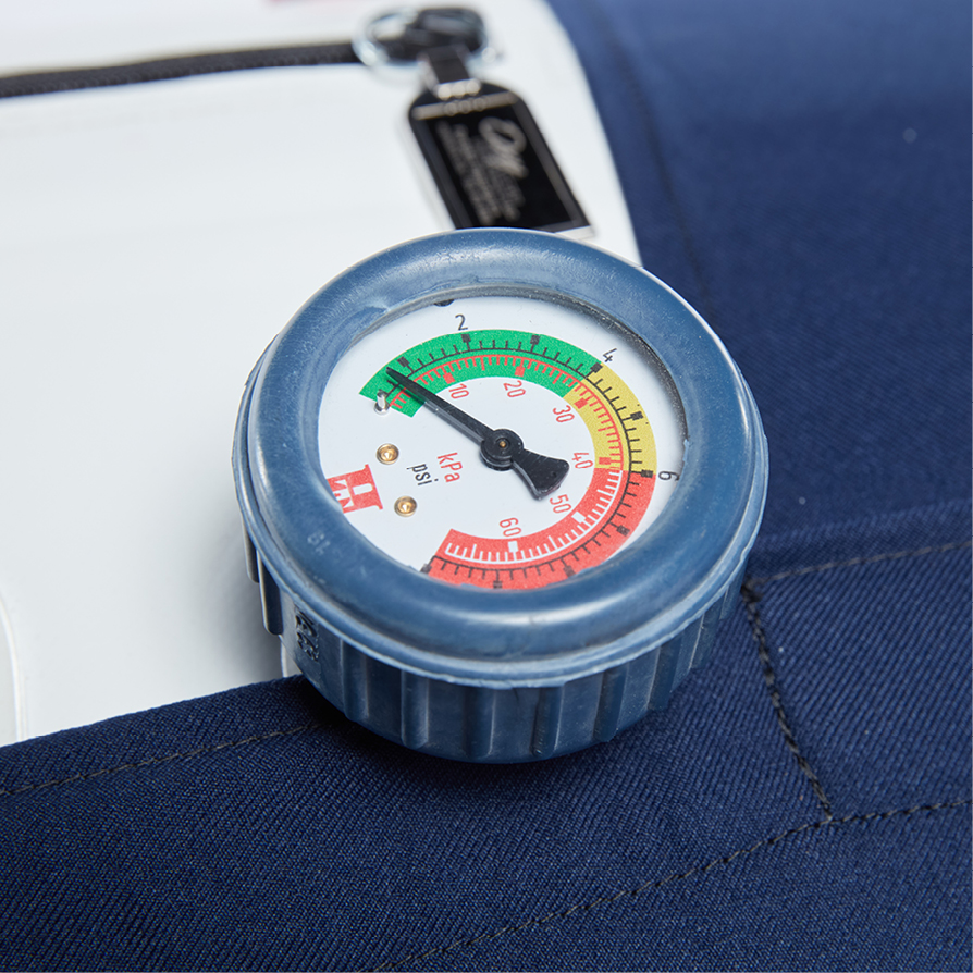 Close-up of a blue pressure gauge showing measurements in kPa and psi with colored zones for pressure levels.