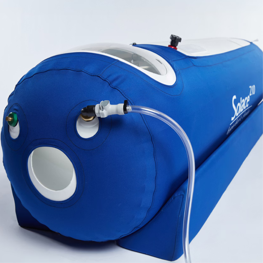 Blue cylindrical hyperbaric oxygen chamber labeled Solace 210 with clear tubing attached.