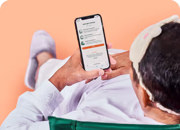 一名年輕亞洲男性正在使用手機，手中拿著一杯咖啡