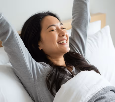 A woman happily waking up from sleep