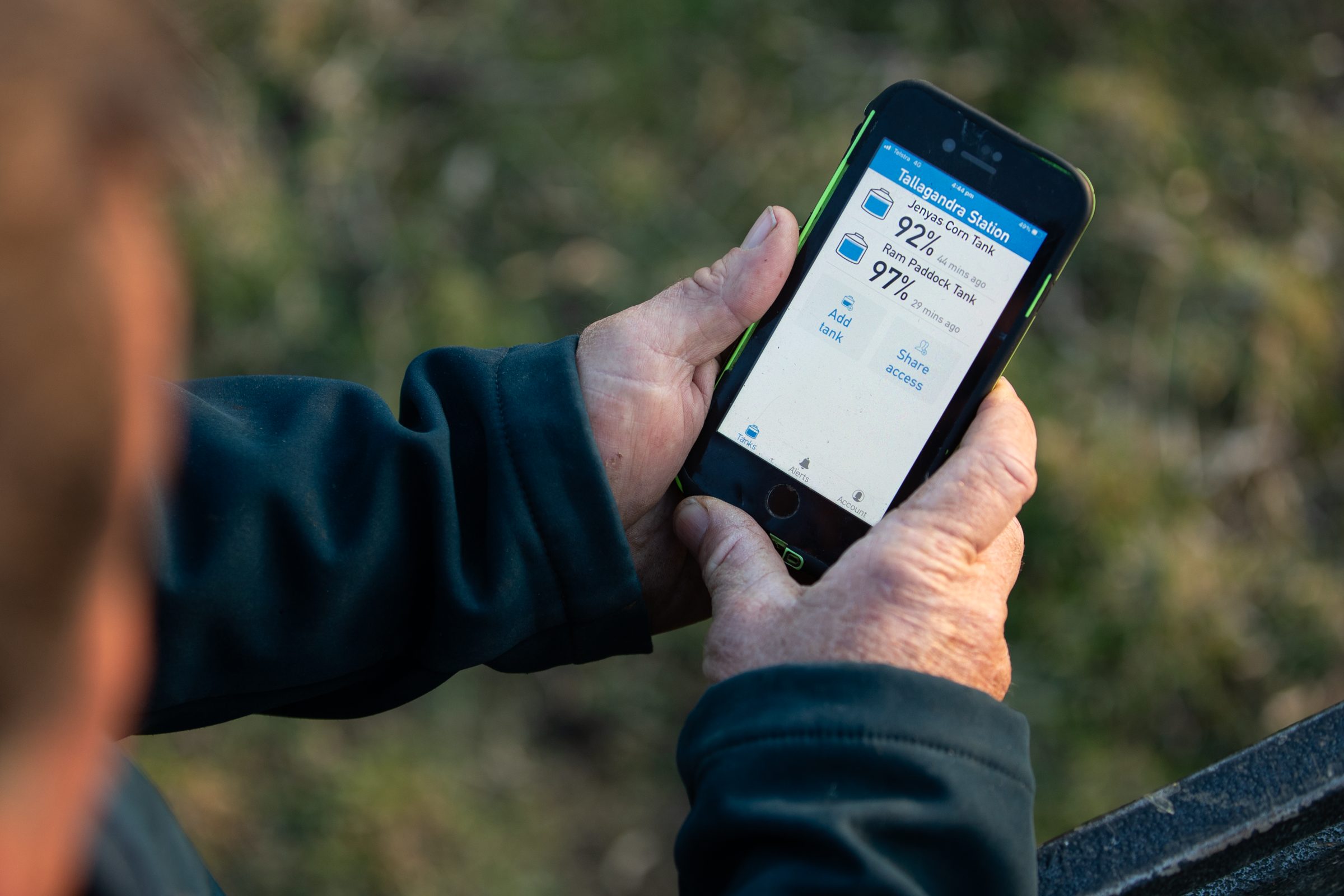 Farmer checking tank levels for two tanks in the HiLo app