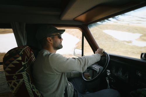 Gonzalo Montoya in Iceland sitting on 4x4 Camper Van