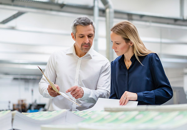 Man and woman looking at paper documents in an office environment