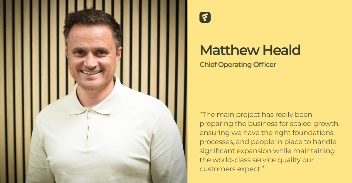 Mann vor einer Wand mit Holzvertäfelung, einem Zitat und den Worten Matthew Heald, Chief Operating Officer