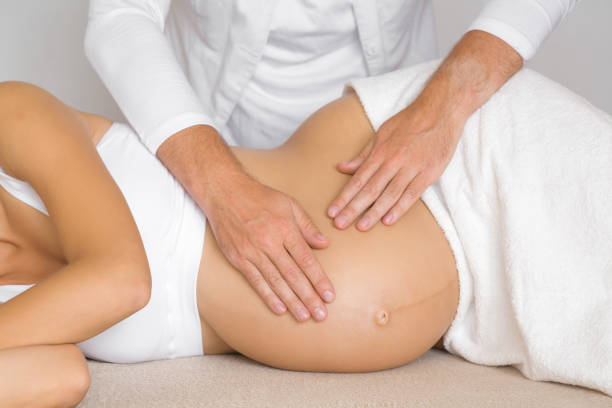 Man hands touching pregnant woman belly. Lying down on side on bed. Body health in pregnancy time. Relaxing day. Close up. Man hands touching pregnant woman belly. Lying down on side on bed. Body health in pregnancy time. Relaxing day. Close up. Pregnancy Massage stock pictures, royalty-free photos & images
