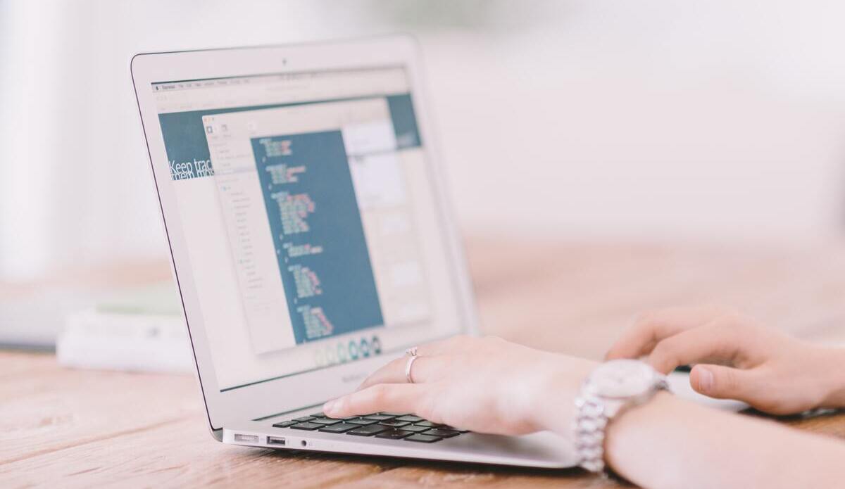 person-working-on-the-laptop-turned-on-the-table