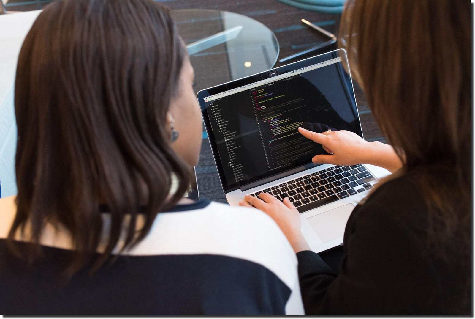 woman-showing-code-on-laptop-to-another-woman