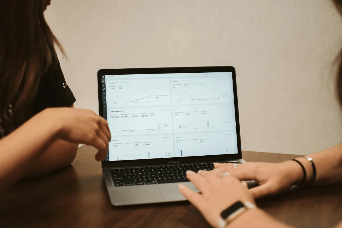 Individuals analyzing digital marketing metrics, such as engagement, growth, and performance graphs.