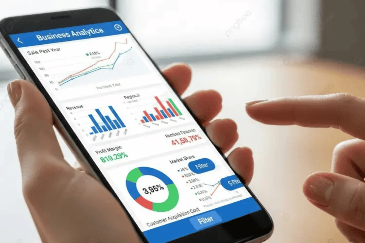 A person holds a smartphone displaying business analytics charts with graphs and pie charts. The screen is vibrant, indicating data insights.