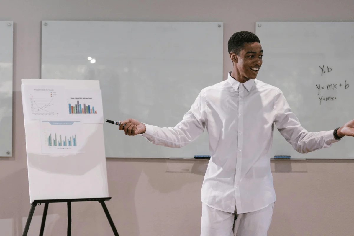 Man giving a business presentation with charts on a flip board.
