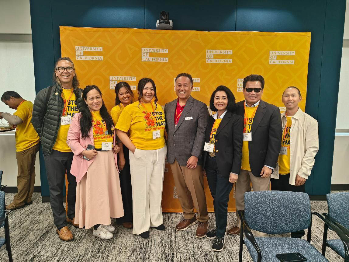 Members of the Pacific Asian Counseling Services smiling in a standing group photo together at an event.
