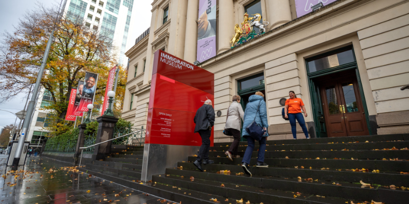 A group of people walking up the steps at The Immigration Museum in Melbourne.