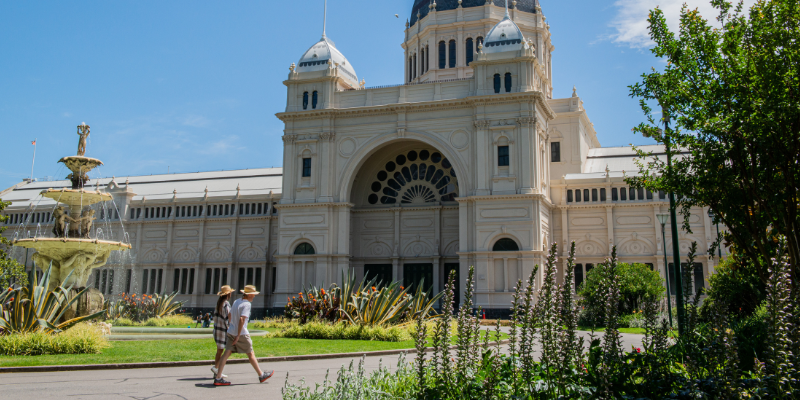 Two people strolling towards the Royal Exhibition Building in Carlton, Melbourne.