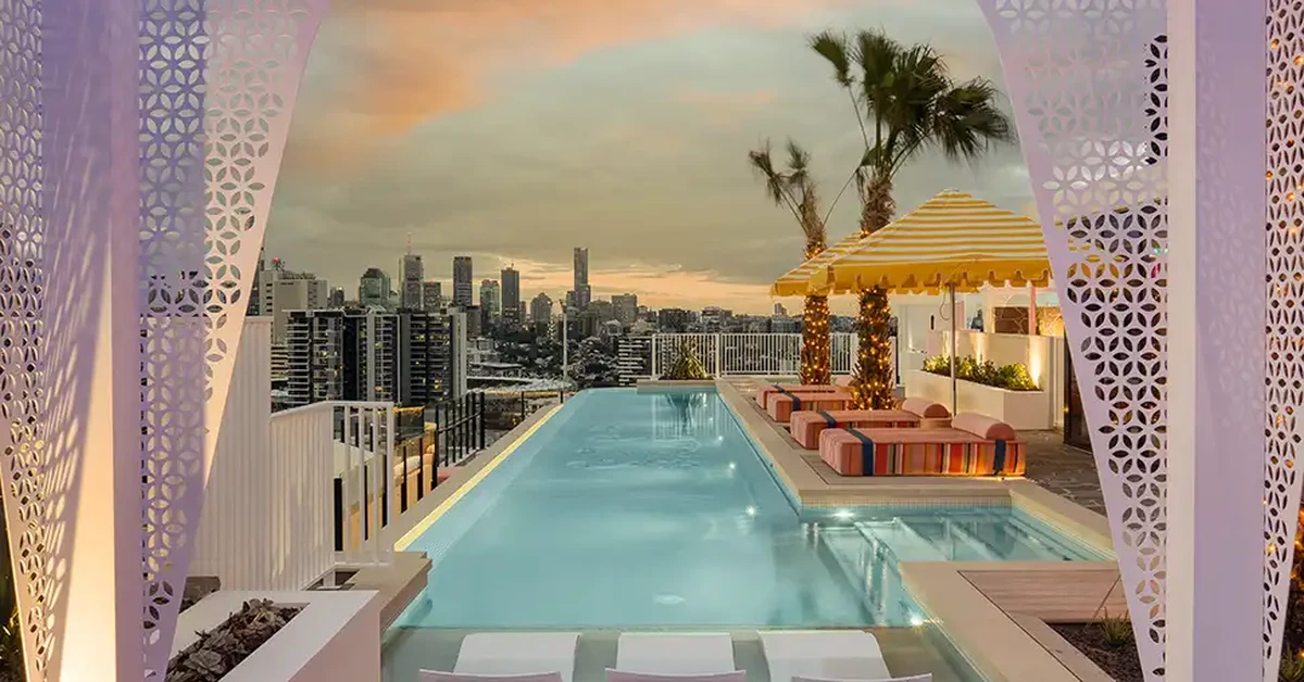 Rooftop pool with panoramic city skyline view at sunset