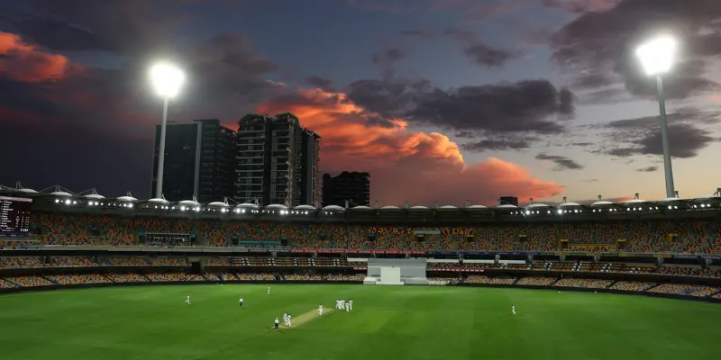 Cricket game at the Gabba under a dramatic sky
