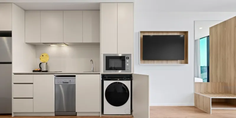 Modern Rambla serviced apartment kitchen with integrated appliances, washing machine and sleek cabinetry.