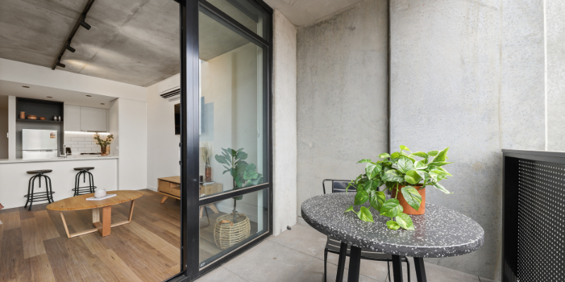 Apartment interior with balcony, table, and plant at Solarino House