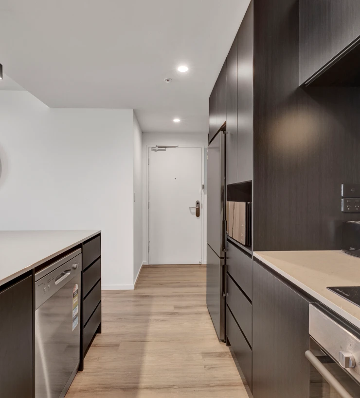 Galley kitchen with dark cabinetry in a two bedroom apartment at Rambla @ Berwick House