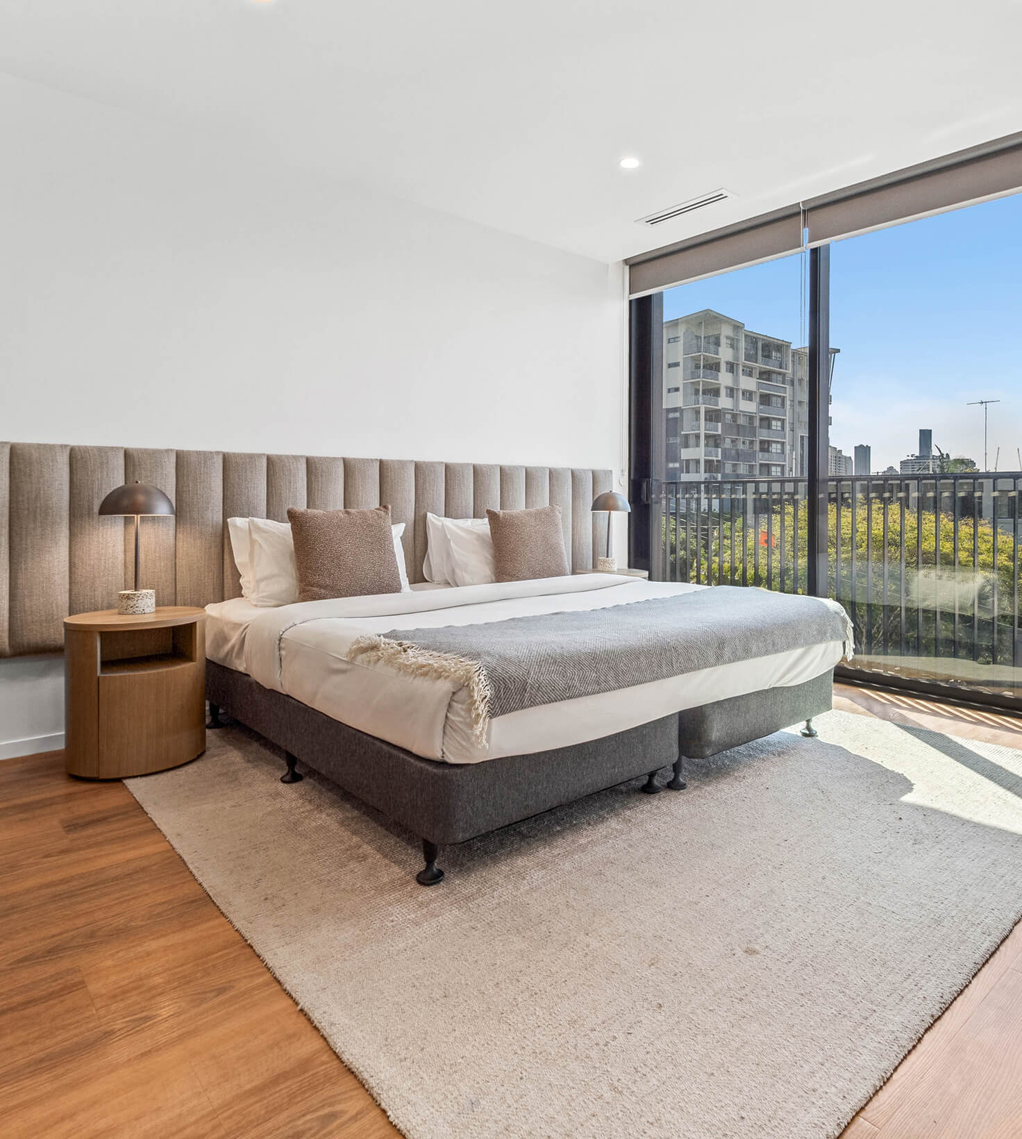 King bed with upholstered bedhead beside the balcony in a Deluxe Studio Apartment at Rambla @ Story House