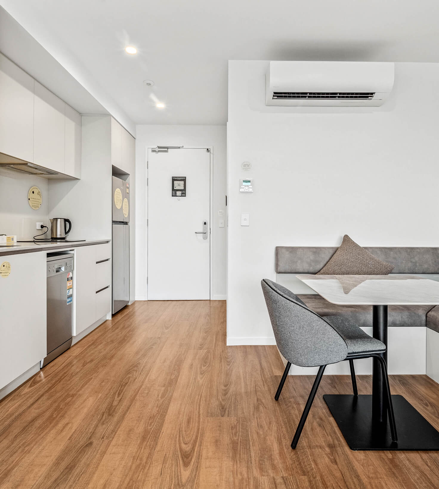 Kitchenette and dining banquette beside the entry in a Deluxe Studio Apartment at Rambla @ Story House