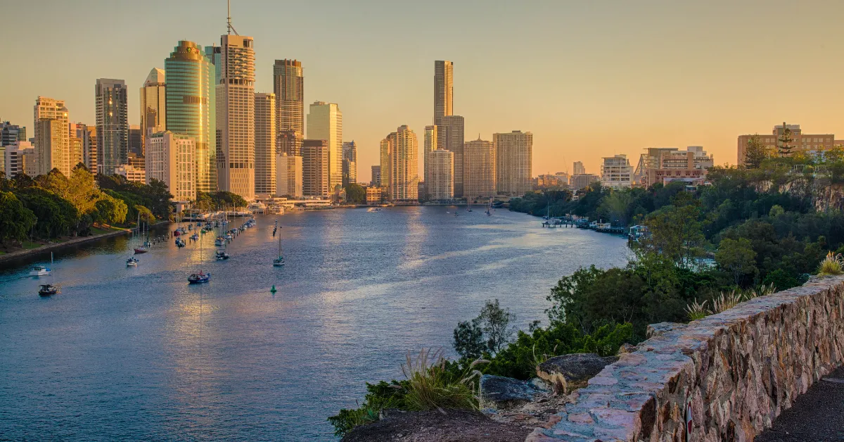 Brisbane City skyline at sunset across the river from Kangaroo Point cliffs lookout.