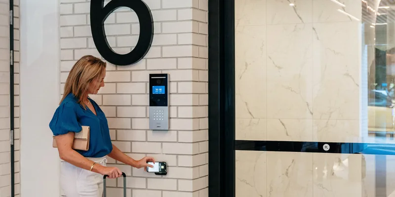 Guest tapping her phone on the entry keypad to unlock the door