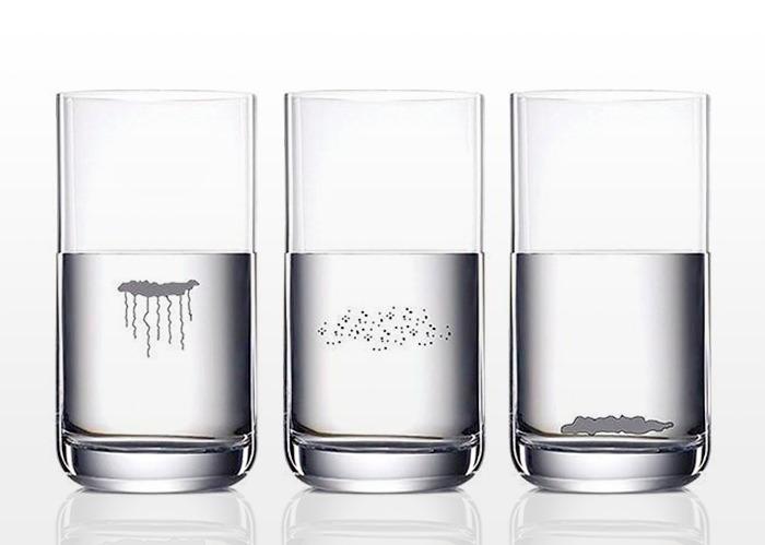 Tres vasos de vidrios llenos de agua después de realizar una prueba casera de cándida, en uno las partículas de saliva flotan, en otro se hunden y en otro se quedan en el medio del vaso