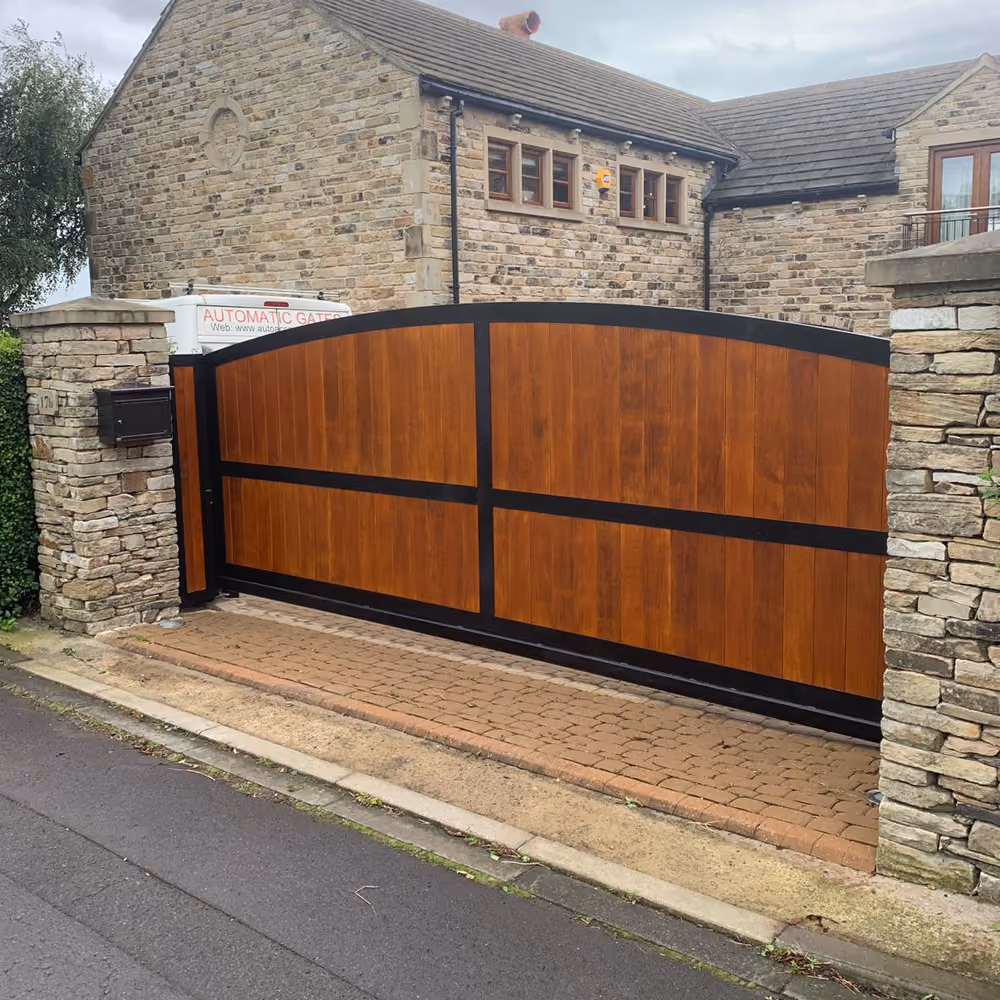 A newly installed automatic wood and black finished sliding gate.