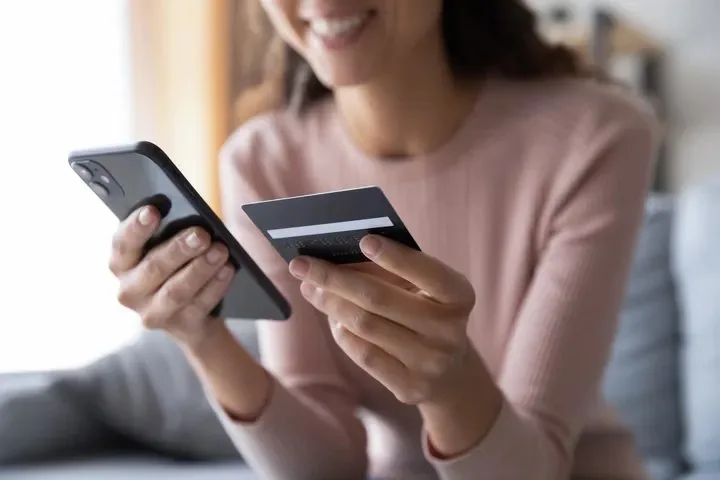 A client shopping on her phone with a credit card