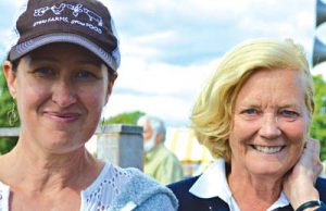 Two older women smiling together outdoors on a sunny day